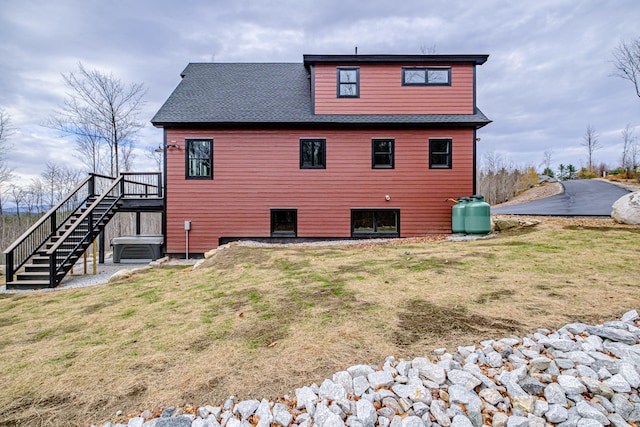 back of property featuring a wooden deck and a yard