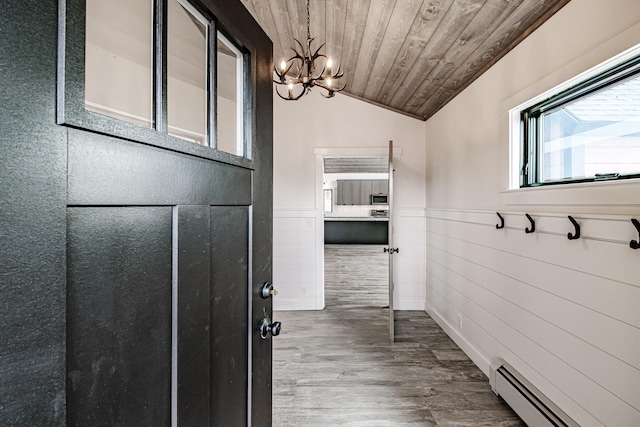 interior space with a baseboard heating unit, wood-type flooring, vaulted ceiling, an inviting chandelier, and wooden ceiling