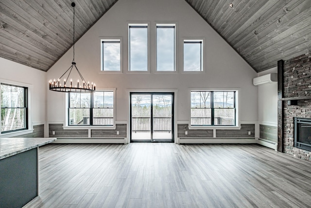 unfurnished living room featuring a stone fireplace, a wall unit AC, light hardwood / wood-style flooring, and plenty of natural light