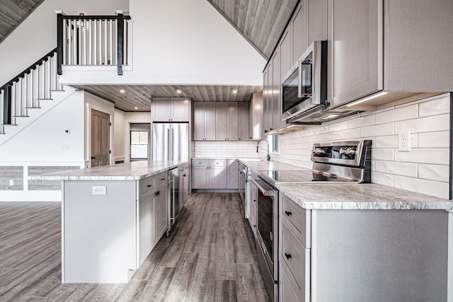 kitchen featuring dark wood-type flooring, wood ceiling, and stainless steel appliances