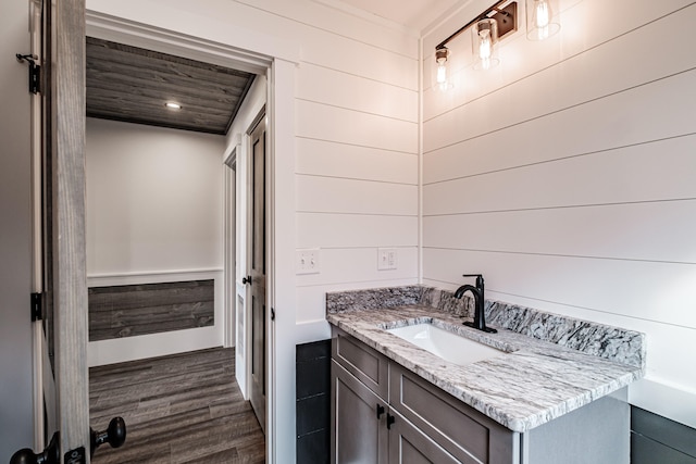 bathroom featuring wood-type flooring, vanity, and wood ceiling