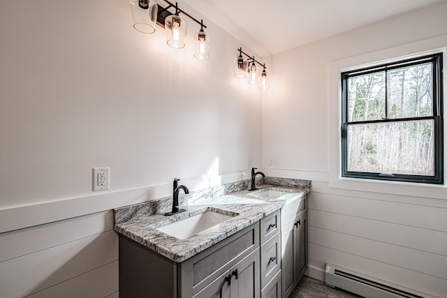 bathroom with vanity, wooden walls, and baseboard heating