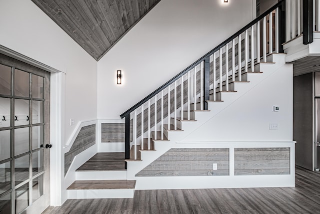 stairway featuring high vaulted ceiling, hardwood / wood-style floors, and wooden ceiling