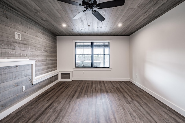 empty room featuring dark hardwood / wood-style flooring, wood walls, wood ceiling, and ceiling fan