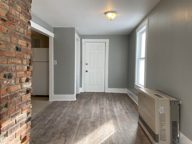 foyer with heating unit and dark hardwood / wood-style flooring