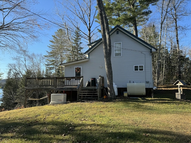 back of property with a deck and a lawn