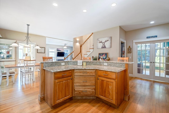 kitchen with pendant lighting, a center island, and light hardwood / wood-style flooring