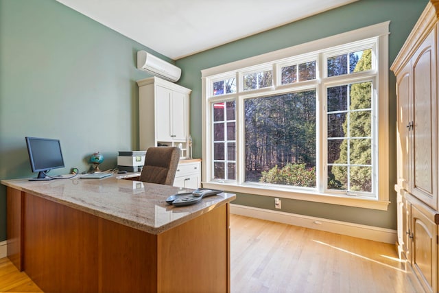 office space featuring light hardwood / wood-style flooring, a wall mounted AC, and a healthy amount of sunlight