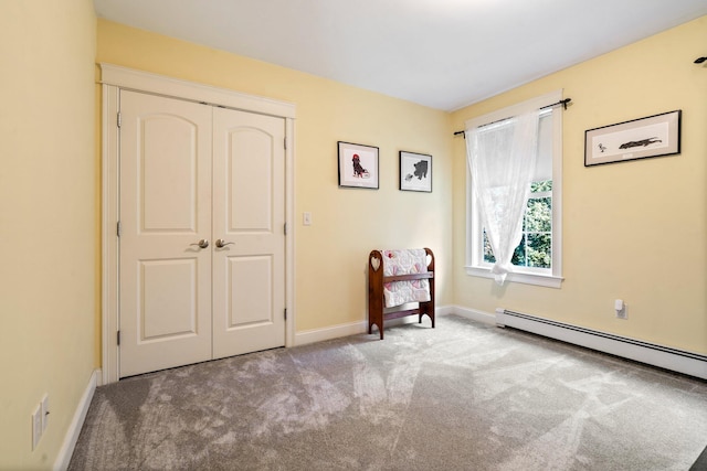 unfurnished room with light colored carpet and a baseboard heating unit