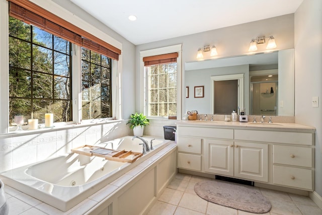 bathroom with separate shower and tub, a wealth of natural light, tile patterned flooring, and vanity