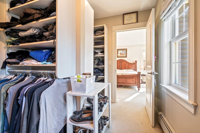 walk in closet with light colored carpet and a baseboard radiator