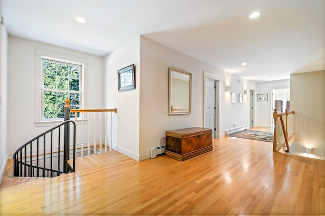 hallway with a baseboard radiator and hardwood / wood-style flooring