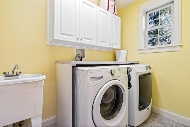 laundry area with cabinets, light tile patterned floors, and washer and clothes dryer