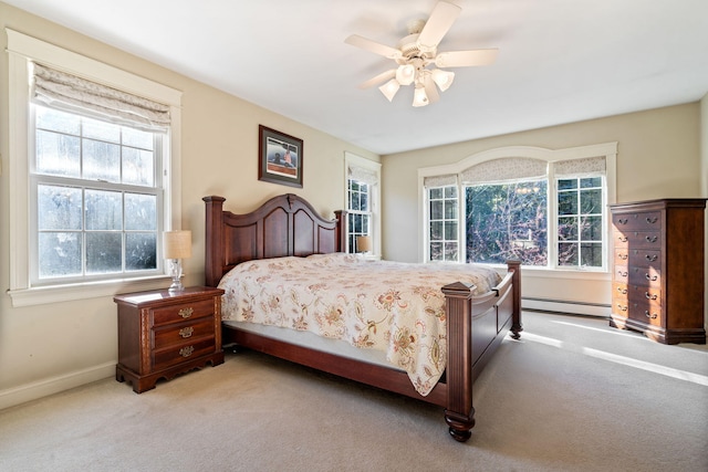 carpeted bedroom featuring ceiling fan, a baseboard radiator, and multiple windows