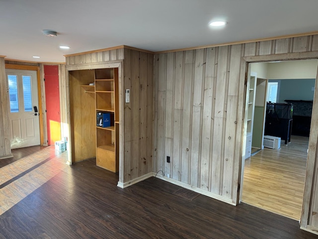 unfurnished room featuring dark hardwood / wood-style floors and wooden walls