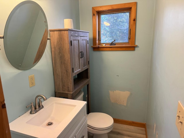 bathroom with vanity, toilet, and wood-type flooring