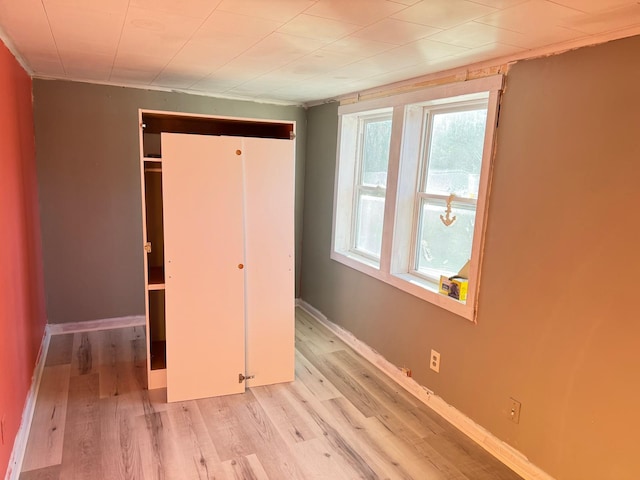 unfurnished bedroom with a closet and light hardwood / wood-style floors