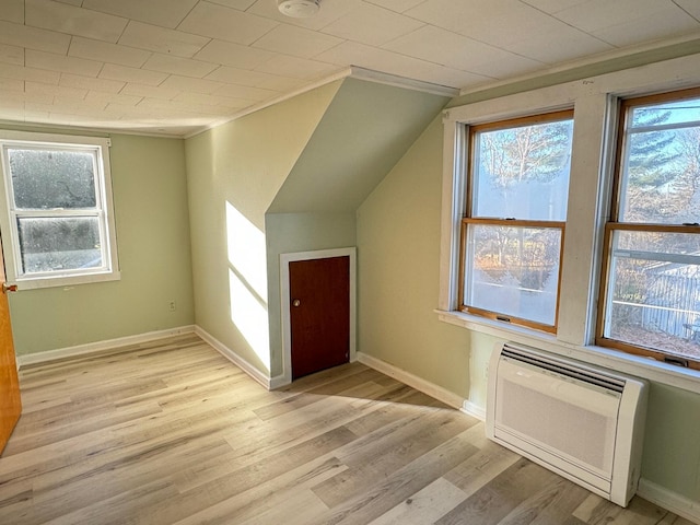 bonus room featuring a wall unit AC and light hardwood / wood-style floors