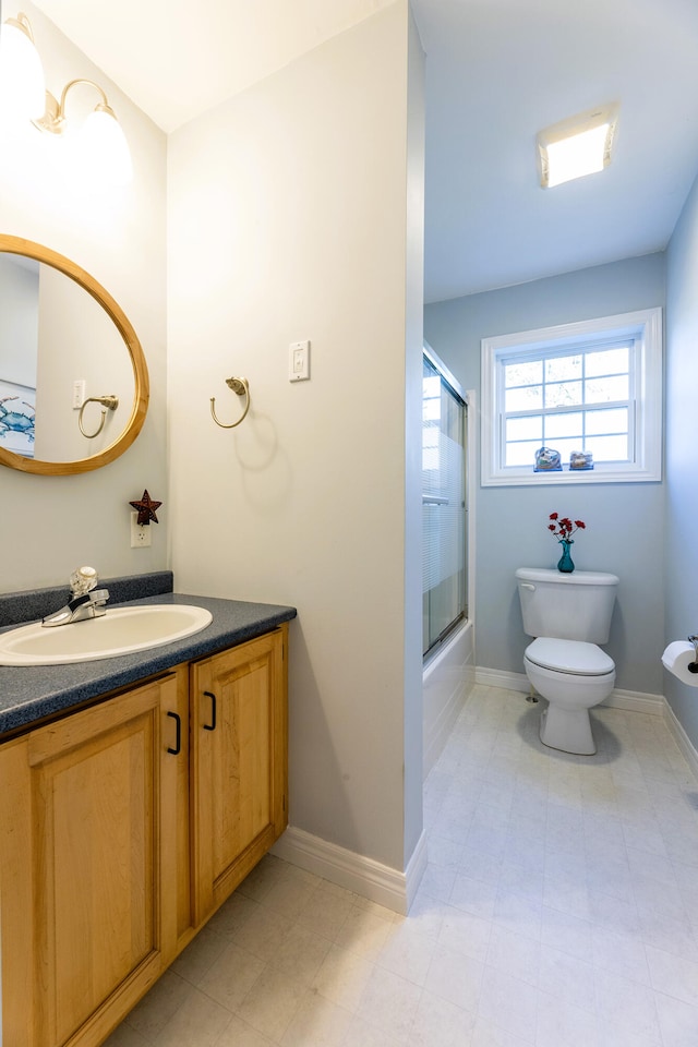 full bathroom featuring shower / bath combination with glass door, vanity, and toilet