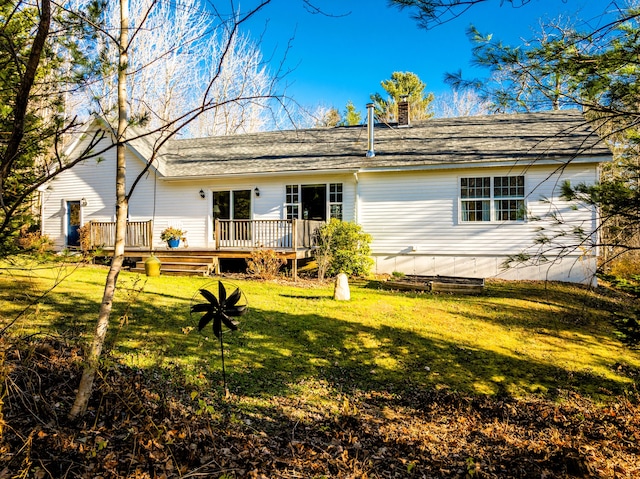 back of house with a deck and a lawn