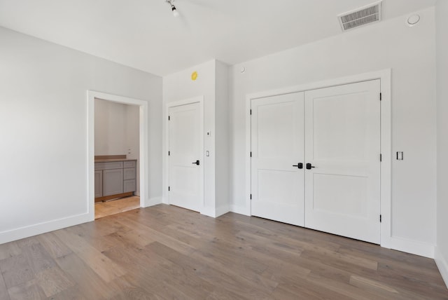 43 Rose Douglas Ln, Brunswick, ME 04011 - unfurnished bedroom with wood finished floors, baseboards, a closet, and visible vents