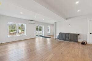 43 Rose Douglas Ln, Brunswick, ME 04011 - unfurnished living room with beamed ceiling, recessed lighting, wood finished floors, and a wall unit AC