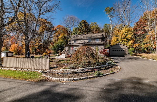 27 Mace Ave, Winthrop, ME 04364 - view of front facade with an outbuilding, a garage, driveway, and fence