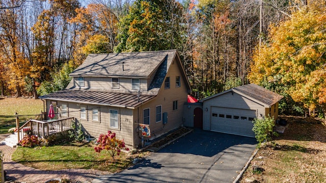 27 Mace Ave, Winthrop, ME 04364 - view of front of home with a standing seam roof, an outbuilding, metal roof, a shingled roof, and a garage