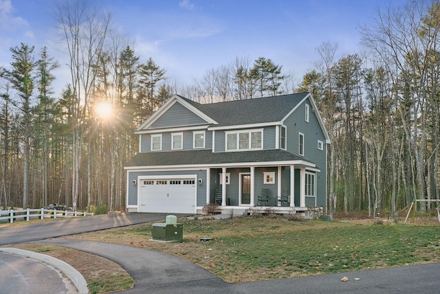 view of front facade with aphalt driveway, roof with shingles, a porch, an attached garage, and a front lawn