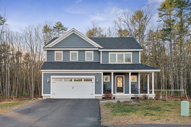 view of front facade with a porch, driveway, a shingled roof, and a garage