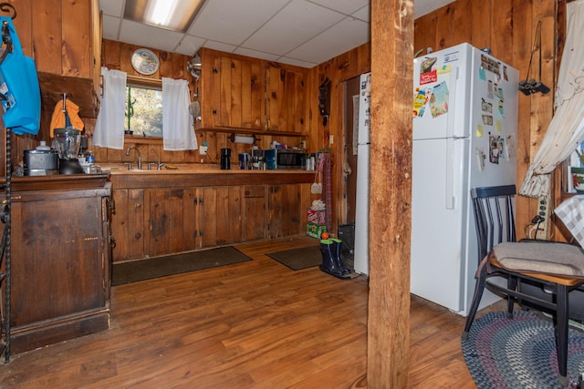 kitchen featuring a paneled ceiling, white fridge, dark hardwood / wood-style floors, and sink