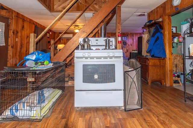 kitchen featuring wood walls, hardwood / wood-style floors, and white electric stove