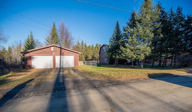 exterior space featuring a lawn, a garage, and an outdoor structure