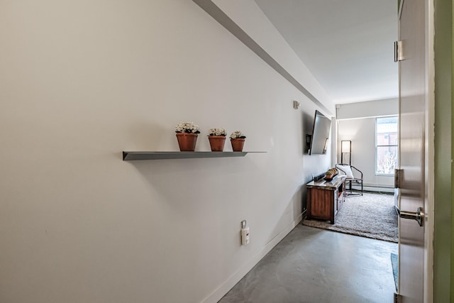 hallway featuring concrete flooring and a baseboard radiator