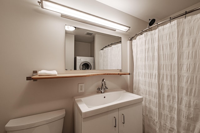 bathroom with washer / dryer, toilet, curtained shower, and sink