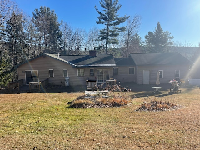 rear view of property with a deck and a yard