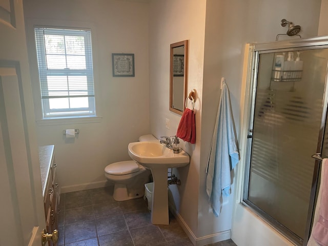 bathroom featuring tile patterned floors, toilet, and enclosed tub / shower combo