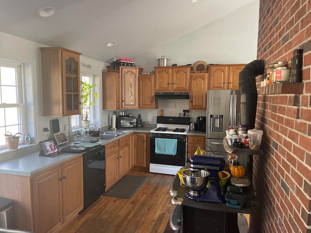 kitchen featuring lofted ceiling, dark hardwood / wood-style floors, white gas stove, and brick wall