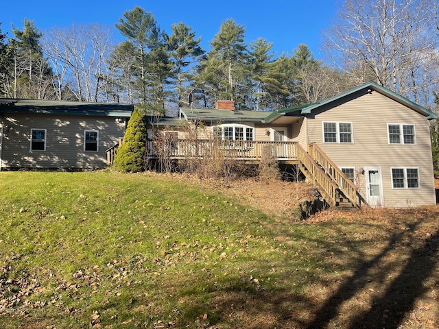 rear view of house featuring a lawn and a wooden deck