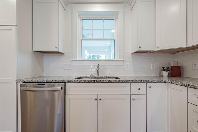 kitchen featuring light stone countertops, white cabinetry, sink, tasteful backsplash, and stainless steel dishwasher