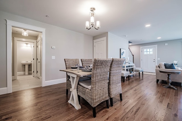 dining space with light hardwood / wood-style floors and an inviting chandelier