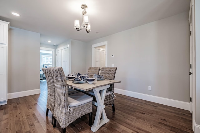 dining area featuring dark hardwood / wood-style floors and an inviting chandelier