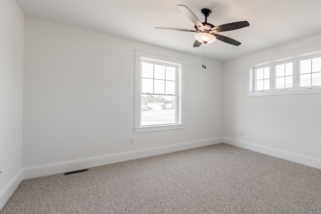 carpeted spare room with ceiling fan