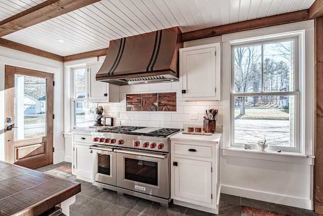 kitchen with a healthy amount of sunlight, white cabinetry, double oven range, and custom range hood