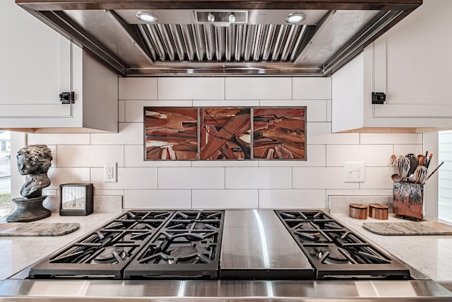 kitchen featuring white cabinets, tasteful backsplash, stainless steel range oven, and wall chimney range hood