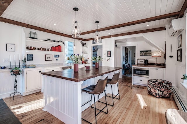 kitchen featuring wood counters, a wall mounted air conditioner, light wood-type flooring, a baseboard heating unit, and white cabinets