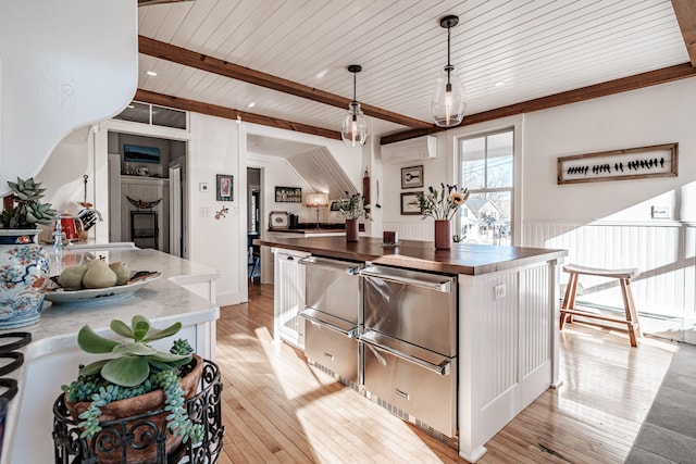 kitchen with a wall mounted air conditioner, wooden ceiling, decorative light fixtures, and light hardwood / wood-style floors