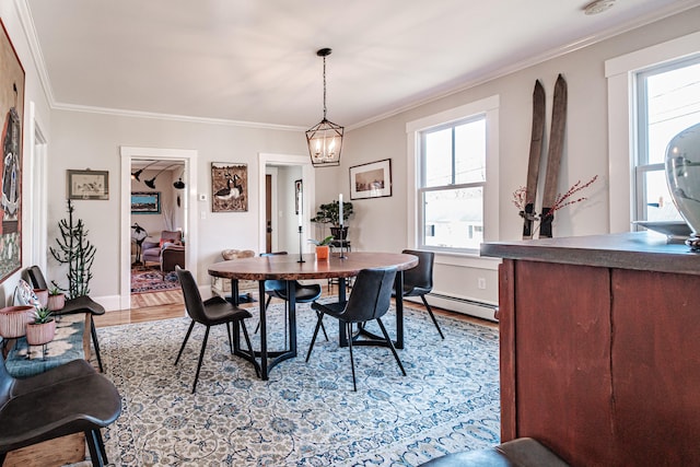 dining area with light wood-type flooring, crown molding, baseboard heating, and an inviting chandelier