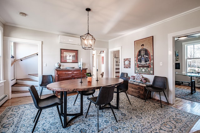 dining area featuring an AC wall unit, crown molding, wood-type flooring, and an inviting chandelier