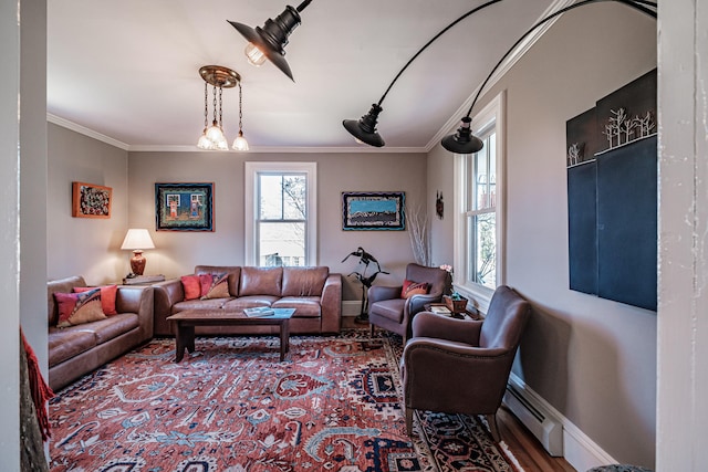 living room with hardwood / wood-style floors, ornamental molding, baseboard heating, and an inviting chandelier